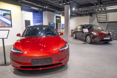 Yeni kırmızı Tesla Model 3, galeride Y elektrikli arabalar, çağdaş Avrupa 'da EV kullanımındaki eğilimler, otomotiv endüstrisindeki son teknolojiler, çevresel olarak sürdürülebilir, Frankfurt - 9 Kasım 2023