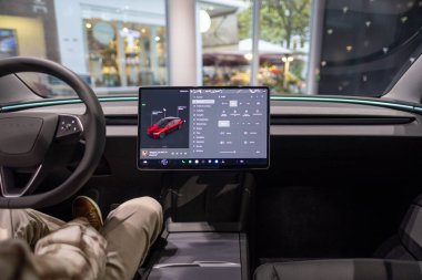 Tesla test sürüşü, genç adam, potansiyel alıcı, arabanın içinde oturur, aracın sistemlerini test eder, otomotiv endüstrisindeki son teknolojileri, çevresel sürdürülebilir, Frankfurt - 9 Kasım 2023