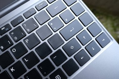 bir dizüstü bilgisayarın yakın çekim bölümü, bir dizüstü bilgisayarın siyah klavyesi, düğmeler, teknoloji konsepti, çalışma, dijital çağda evden öğrenme, tam zamanlı telesekretere aktarma