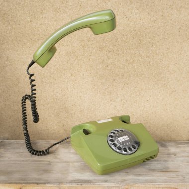 Disk kadranlı eski yeşil Rotary Telefon, telefon ahizesi havada uçuşuyor, havada uçuyor, Güvenli İletişim, Modası geçmiş Teknoloji, Retro Estetik 80 'ler