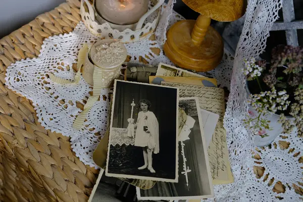 burning candle, lace, old chest of drawers shabby chic, stack of retro photos of 50-60s, dried flowers, concept of family tree, genealogy, connection with ancestors, memories of youth