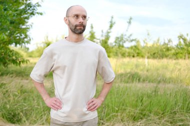 30-35 yaşlarında, açık tişörtlü, şık gözlüklü, doğal arka planda, Gençlik Kültürü ve Stereotipli, genç nesil, giysiler, aksesuarlar, açık hava aktiviteleri...