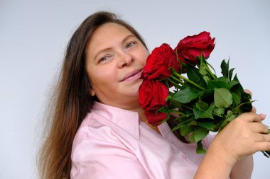 Çiçek buketi, kırmızı güller mutlu olgun bir kadının ellerinde 50 yaşında, eğleniyor, kırmızı güllerle şenlik havasında, tebrikler, anneler günü, doğum günü, seçici odaklanma.