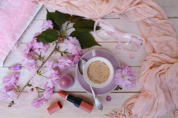 cup with drink coffee cappuccino, lipstick, pink sakura flowers, female life, caffeine improves functioning of human brain, stimulates nervous system, health benefits and harms, copy space, banner