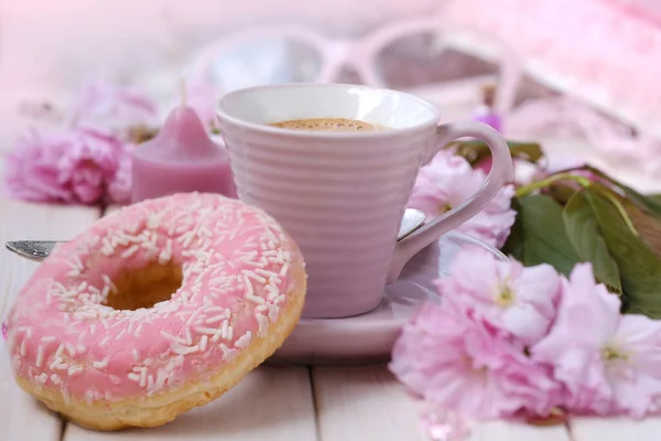 cup with drink coffee cappuccino, hot chocolate with milk, pink donut, spring sakura flowers, caffeine improves functioning of human brain, stimulates nervous system, health benefits and harms