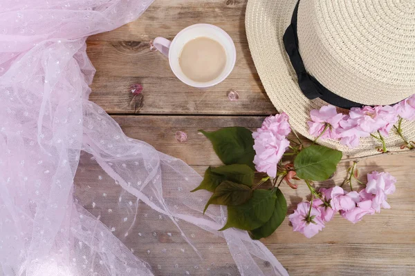 cup with drink coffee cappuccino, hot chocolate with milk, light sunhat, pink sakura flowers, caffeine improves functioning of human brain, stimulates nervous system, health benefits and harms