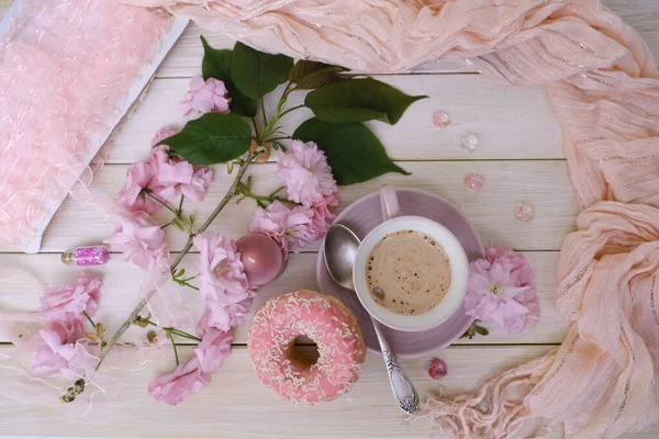 cup with drink coffee cappuccino, hot chocolate with milk, pink donut, scarf, sakura flowers, caffeine improves functioning of human brain, stimulates nervous system, health benefits and harms
