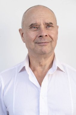 Karizmatik olgun bir adamın yakın çekimi, son sınıf öğrencisi 60 yaşında. Yüzündeki kırışıklıkları, cilt kıvrımlarını, yaşla ilgili deri değişikliklerini, estetik enjeksiyon kozmetolojisini, bakım yaşlanmayı önleyici prosedürleri dikkatle inceliyor.