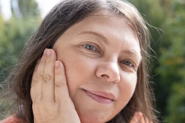 成熟した女性の顔のクローズアップ 50歳の女性は慎重にしわ 肌の欠陥 顔の毛 年齢に関連する変化 審美的な化粧品 アンチエイジング手順を調べます — ストック写真