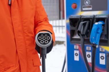 DC 'yi tutan adam, HPC şarj konnektörü, elektrikli araç CCS2 hızlı şarj istasyonu, Avrupa' da alternatif enerji, teknoloji ve yenilik otomotiv endüstrisi, Frankfurt - 21 Ocak 2024