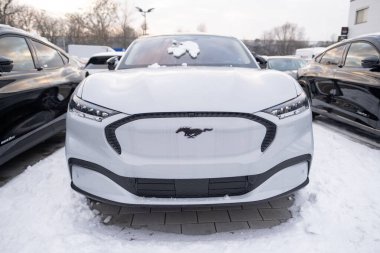 Beyaz elektrikli araba Ford Mustang Mach-E kış otoparkında, EV Avrupa, otomotiv endüstrisinde teknolojik gelişmeler, çevre temizliği aracı, Frankfurt, Almanya - 19 Ocak 2024