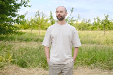 30-35 yaşlarında, açık tişörtlü, şık gözlüklü, doğal arka planda, Gençlik Kültürü ve Stereotipli, genç nesil, giysiler, aksesuarlar, açık hava aktiviteleri...