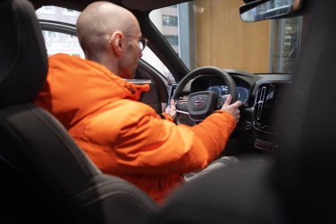 Genç adam iç mekanı, Volvo xc40 'ın kokpitini, dijital paneli, direksiyondaki aletleri, EV teknoloji otomotiv endüstrisini, Frankfurt' taki çevre aracını inceliyor - 22 Ocak 2024