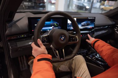 BMW i5 eDrive40 kullanan adam, dijital panel, iç mekan, kokpit modern EV, erkek eller direksiyonda, sürücü güvenliği, Avrupa 'da çevre aracı, Frankfurt, Almanya - 22 Ocak 2024