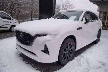 beyaz Mazda CX-90 Hibrit Elektrikli SUV park yerinde kar, Japon otomobil şirketi otomobil salonu, otomotiv endüstrisi, Sürdürülebilir Ulaşım, Frankfurt, Almanya - 19 Ocak 2024