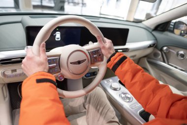 Erkek eller direksiyona, içişlerine, Genesis GV60 Electric Car 'ın kokpitine, Kore markası Hyundai Company, Avrupa' da EV, otomotiv endüstrisinde yenilik, Frankfurt, Almanya - 31 Ocak 2024