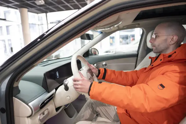 Genesis GV60 Electric Car kullanan bir adam, direksiyonda, içte, kokpitte, Kore markalı Hyundai şirketinde, otomotiv endüstrisinde yenilik, Frankfurt, Almanya - 31 Ocak 2024