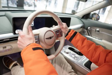 Erkek eller direksiyona, içişlerine, Genesis GV60 Electric Car 'ın kokpitine, Kore markası Hyundai Company, Avrupa' da EV, otomotiv endüstrisinde yenilik, Frankfurt, Almanya - 31 Ocak 2024