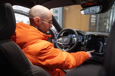 Erkek Eller Sürücülerin Kolunda, BMW i5 eDrive40 yeniden şarj, dijital panel, iç mekan, kokpit modern EV, sürücü güvenliği, Avrupa, Frankfurt, Almanya 'da çevre aracı - 22 Ocak 2024