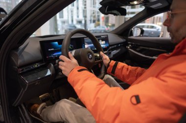BMW i5 eDrive40 kullanan adam, dijital panel, iç mekan, kokpit modern EV, erkek eller direksiyonda, sürücü güvenliği, Avrupa 'da çevre aracı, Frankfurt, Almanya - 22 Ocak 2024