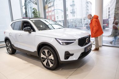 Genç adam inceler, beyaz yeni Volvo xc40 Electric Car 'ı seçer, sergi salonunda İsveç şirketi Volvo Cars, Avrupa' da EV, Frankfurt, Almanya 'da icat otomotiv endüstrisi - 22 Ocak 2024