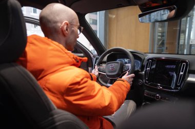 Erkek Eller Sürücülerin Kolunda, BMW i5 eDrive40 yeniden şarj, dijital panel, iç mekan, kokpit modern EV, sürücü güvenliği, Avrupa, Frankfurt, Almanya 'da çevre aracı - 22 Ocak 2024