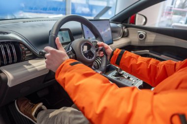 Erkek eller direksiyonda, iç mekanda, BYD ATTO 3 Car in Studio 'nun kokpiti, test sürüşü, elektrikli araç Çinli BYD üreticisi, otomotiv endüstrisi, Frankfurt, Almanya - 31 Ocak 2024