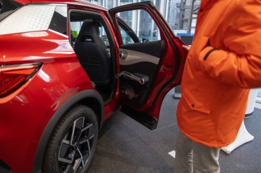 Genç adam inceler, Stüdyoda yeni kırmızı BYD ATTO 3 Car, test sürüşü, elektrikli araç Çinli BYD üreticisi, galeride C-SUV, otomotiv endüstrisi, Frankfurt, Almanya - 31 Ocak 2024