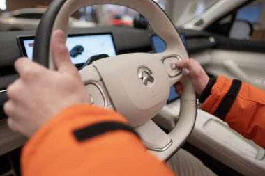 Dümeni NIO EL7, yakın çekim erkek sürücü eli elektronik ekran, iç mekan, kokpit modern EV, Test Çin Elektro-SUV, sürücü güvenliği, Frankfurt, Almanya - 31 Ocak 2024