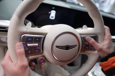 Erkek eller direksiyona, içişlerine, Genesis GV60 Electric Car 'ın kokpitine, Kore markası Hyundai Company, Avrupa' da EV, otomotiv endüstrisinde yenilik, Frankfurt, Almanya - 31 Ocak 2024