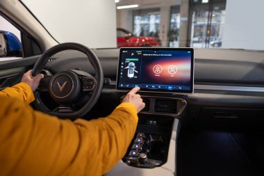 Erkek eller, test sürüşü sırasında vites, sürükleyici direksiyon Vinfast vf 8 elektrikli geçiş, potansiyel alıcılar tarafından test ve değerlendirme araçları, Berlin, Almanya - 17 Şubat 2024