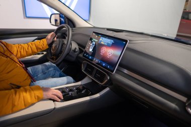 Erkek elleri direksiyonda, iç mekanda, Vinfast vf 8 'in pilot kabininde elektrik geçişi, Vietnam otomotiv endüstrisinde gelişmiş teknolojiler, test sürüşleri, Berlin, Almanya - 17 Şubat 2024