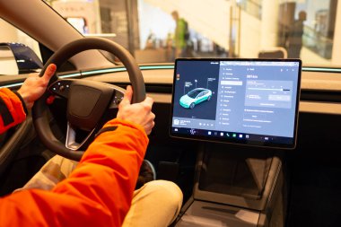 Yakın çekimli erkek direksiyon, Tesla elektrikli araba modeli 3 iç mekan, kokpit modern EV teknolojileri araba üretimi, böyle otomatik pilot, çevre dostu motorlar, Berlin, Almanya - 17 Şubat 2024