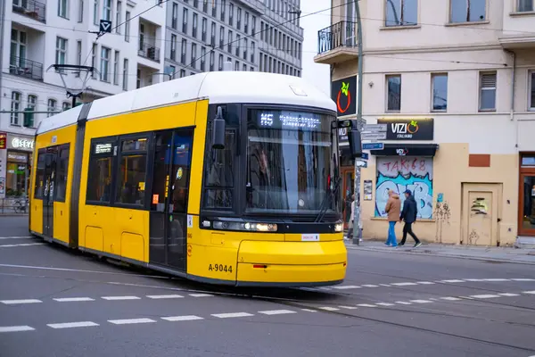 Stock image yellow tram Flexity Berlin driving down city street in Berlin, travel, tourism and city breaks, Everyday City life, eco-friendly public transportation system, Berlin, Germany - February 18, 2024