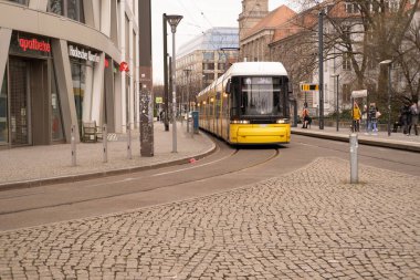 Berlin 'de şehir caddesinden geçen sarı tramvay Flexity Berlin, seyahat, turizm ve şehir molaları, çevre dostu toplu taşıma sistemi, Berlin, Almanya - 18 Şubat 2024