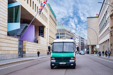 Berlin 'de İngiliz Konsolosluğu yakınlarındaki caddeye park etmiş beyaz ve yeşil polis otobüsü, sembol kanunu ve düzeni, ulusal güvenliğin korunmasında uluslararası işbirliği, Berlin, Almanya - 18 Şubat 2024