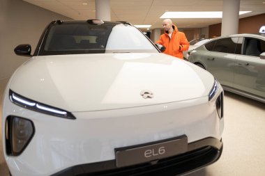 İnsan, Studio 'da yeni beyaz NIO EL6 Electric Car, Showroom' da Nio marka SUV, Avrupa 'da EV, otomotiv endüstrisinde Eco-Friendly Innovation, Frankfurt, Almanya - 31 Ocak 2024