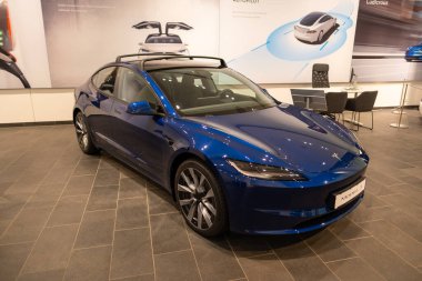 mavi Tesla elektrikli araba modeli Stüdyo 3, otomatik pilot ve çevre dostu motorlar, ev Çevresel sürdürülebilirlik, otomotiv endüstrisi ve karbon emisyonlarının azaltılması, Berlin, Almanya - 17 Şubat 2024