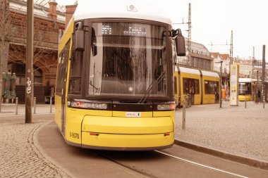Berlin 'de şehir sokağından geçen sarı tramvay Flexity Berlin, seyahat, turizm ve şehir molaları, Everyday City hayatı, çevre dostu toplu taşıma sistemi, Berlin, Almanya - 18 Şubat 2024