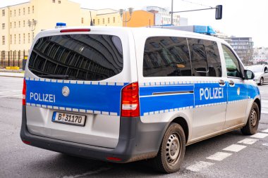 Berlin 'de sokağa park etmiş beyaz ve mavi polis otobüsü, sembol kanunu ve düzeni, acil durum müdahalesi, ulusal güvenliğin korunmasında uluslararası işbirliği, Berlin, Almanya - 18 Şubat 2024