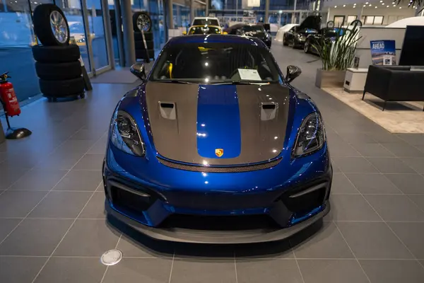 stock image powerful blue-grey Porsche 718 Cayman GT4 RS racing car parked in showroom, showcasing automotive performance, German engineering, Automotive performance, Wiesbaden, Germany - January 25, 2024