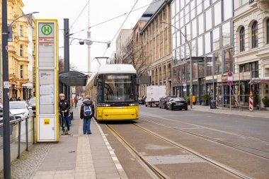 Berlin 'de şehir caddesinden geçen sarı tramvay Flexity Berlin, seyahat, turizm ve şehir molaları, çevre dostu toplu taşıma sistemi, Berlin, Almanya - 18 Şubat 2024