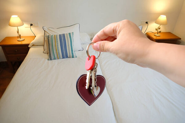 modern bright room, hand with bunch keys, modern bright Comfortable Family Bed, on bedside tables glow lamps, Peaceful Sleep in Spacious Bed