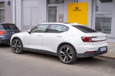 Berlin caddesinde modern beyaz araba Polestar 2, kentsel çevrede çevre dostu elektrikli araç, otomotiv endüstrisi, sürdürülebilir ulaşım, Berlin, Almanya - 18 Şubat 2024