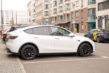 Berlin caddesinde beyaz Tesla Model arabası, kentsel çevrede çevre dostu araç, sürdürülebilir ulaşım, otomotiv endüstrisinde son teknolojiler, Berlin, Almanya - 18 Şubat 2024