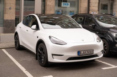 Berlin caddesindeki beyaz model araba, şehir çevresindeki çevre dostu araç, sürdürülebilir ulaşım, otomotiv endüstrisindeki son teknolojiler, Berlin, Almanya - 18 Şubat 2024