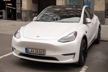 Berlin caddesinde beyaz Tesla Model arabası, kentsel çevrede çevre dostu araç, sürdürülebilir ulaşım, otomotiv endüstrisinde son teknolojiler, Berlin, Almanya - 18 Şubat 2024