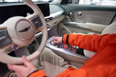 Genesis GV60 Electric Car kullanan adam, düğme düğmeleri, joystickler, SUV Kore markası Hyundai şirketi, dahili ekipman, sürücü güvenliği, Frankfurt, Almanya - 31 Ocak 2024