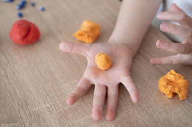 little girl's hands rolling colorful playdough balls, colorful clay, determination creates something special, concept fine motor skills, tactile sensations, creativity clipart