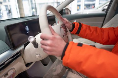 Erkek eller direksiyona, içişlerine, Genesis GV60 Electric Car 'ın kokpitine, Kore markası Hyundai Company, Avrupa' da EV, otomotiv endüstrisinde yenilik, Frankfurt, Almanya - 31 Ocak 2024